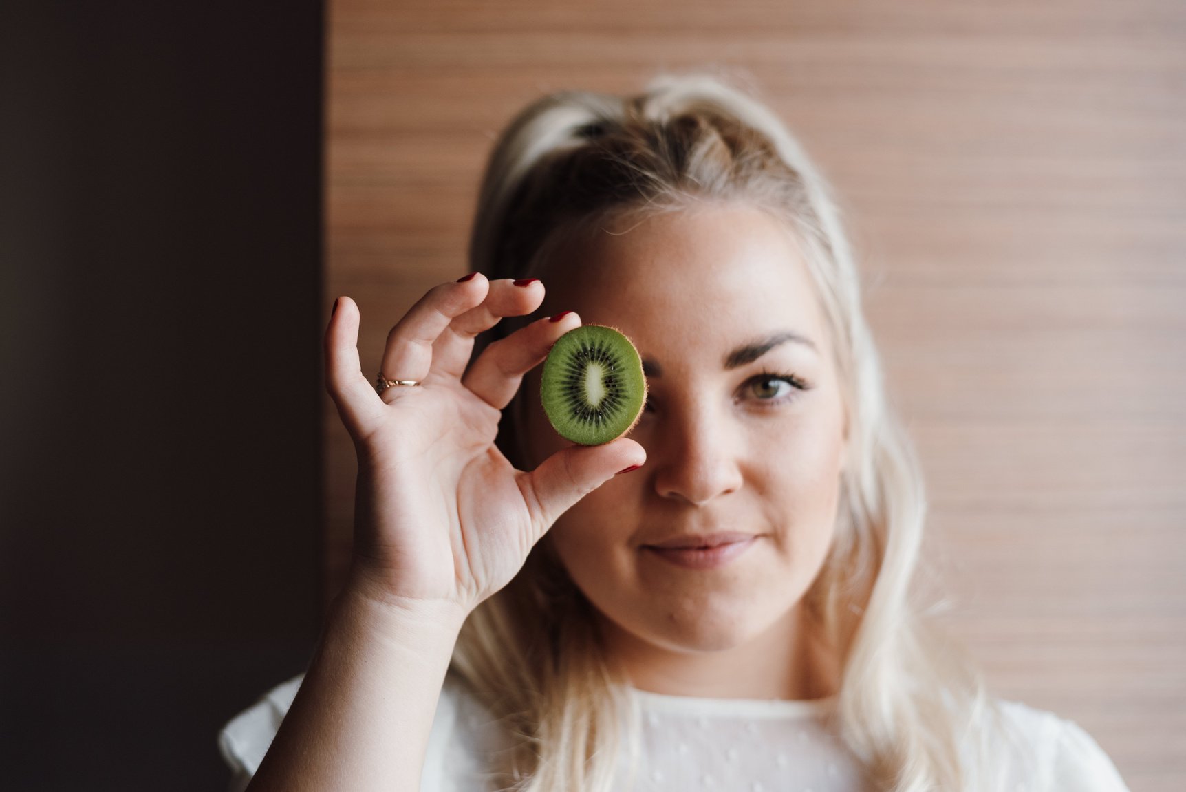 Healthy woman with half of kiwi