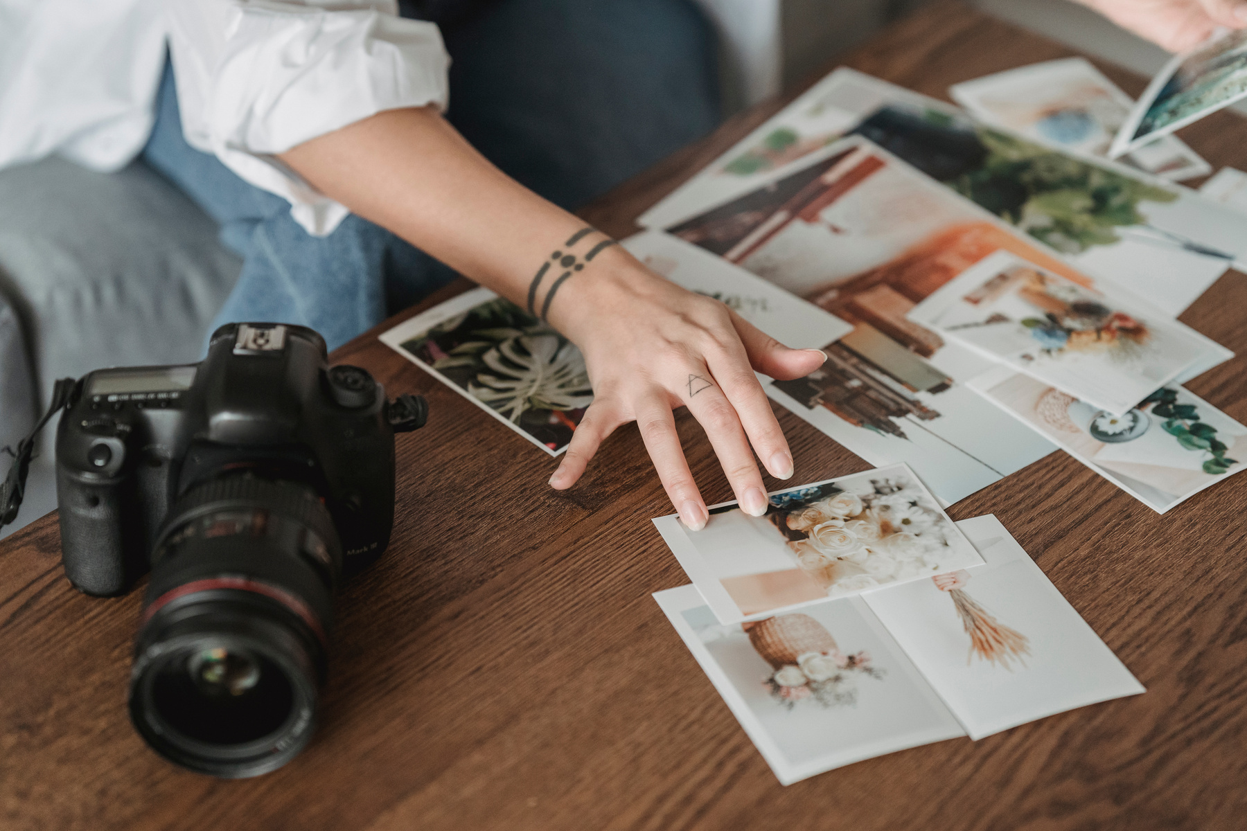 Faceless photographer choosing photos at table with digital camera