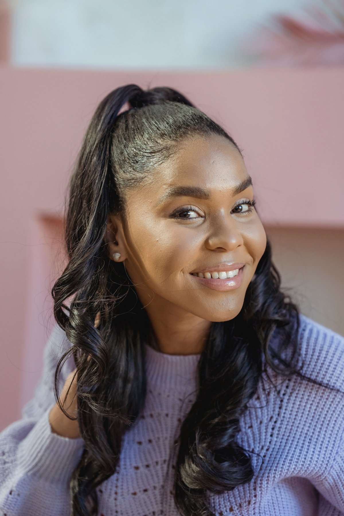 Smiling black woman touching wavy hair